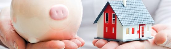 Hands holding piggy bank and house model, buying a home in bend Oregon