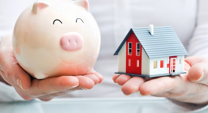 Hands holding piggy bank and house model, buying a home in bend Oregon