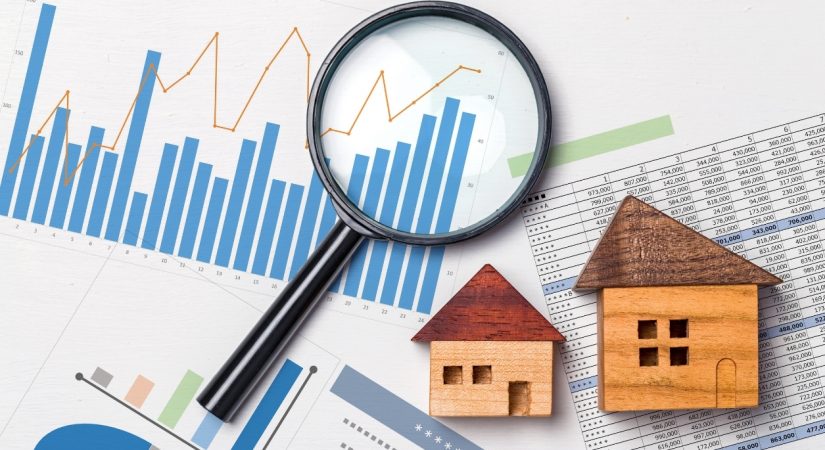 magnifying glass and wooden house models on top of graphs home inspection